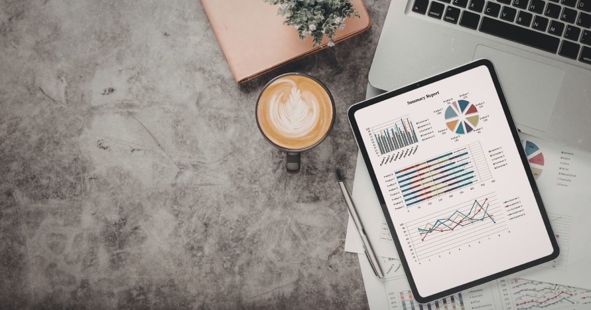 Cold brew coffee next to notebooks and a laptop on a library desk during a study session