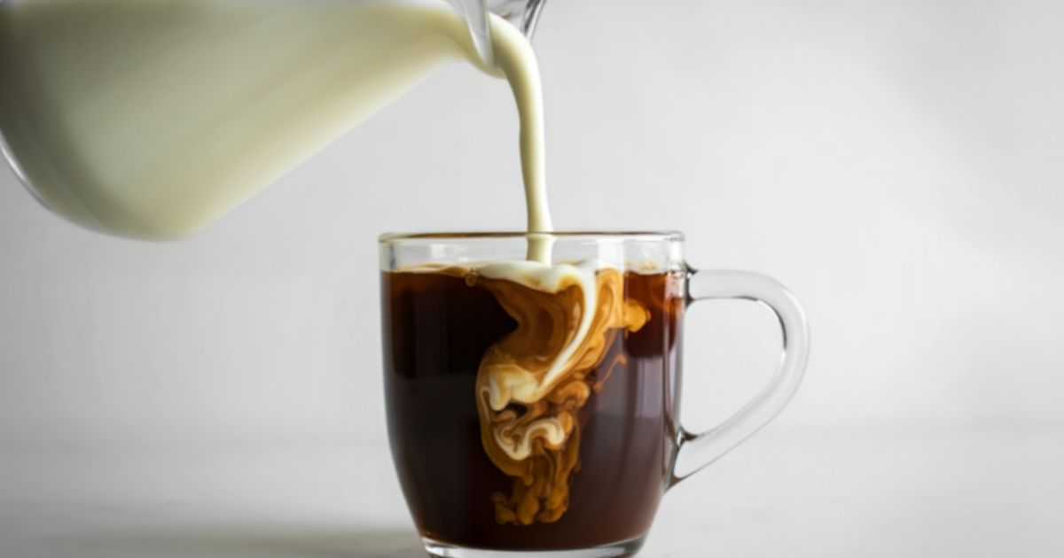 Four glasses of non-dairy milk — oat, almond, soy, and coconut — next to a cup of espresso