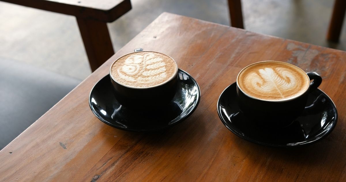 A Dunkin' iced coffee and a Starbucks iced coffee side by side on a table for comparison
