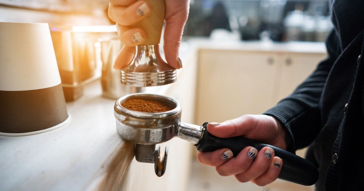 A barista customizing a Starbucks drink with syrup pumps and milk