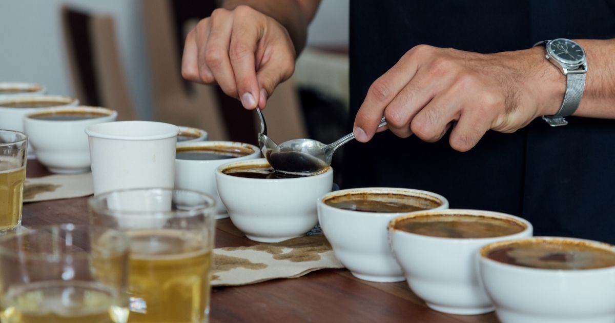 Row of Starbucks syrup bottles including vanilla, caramel, and brown sugar next to customized drinks