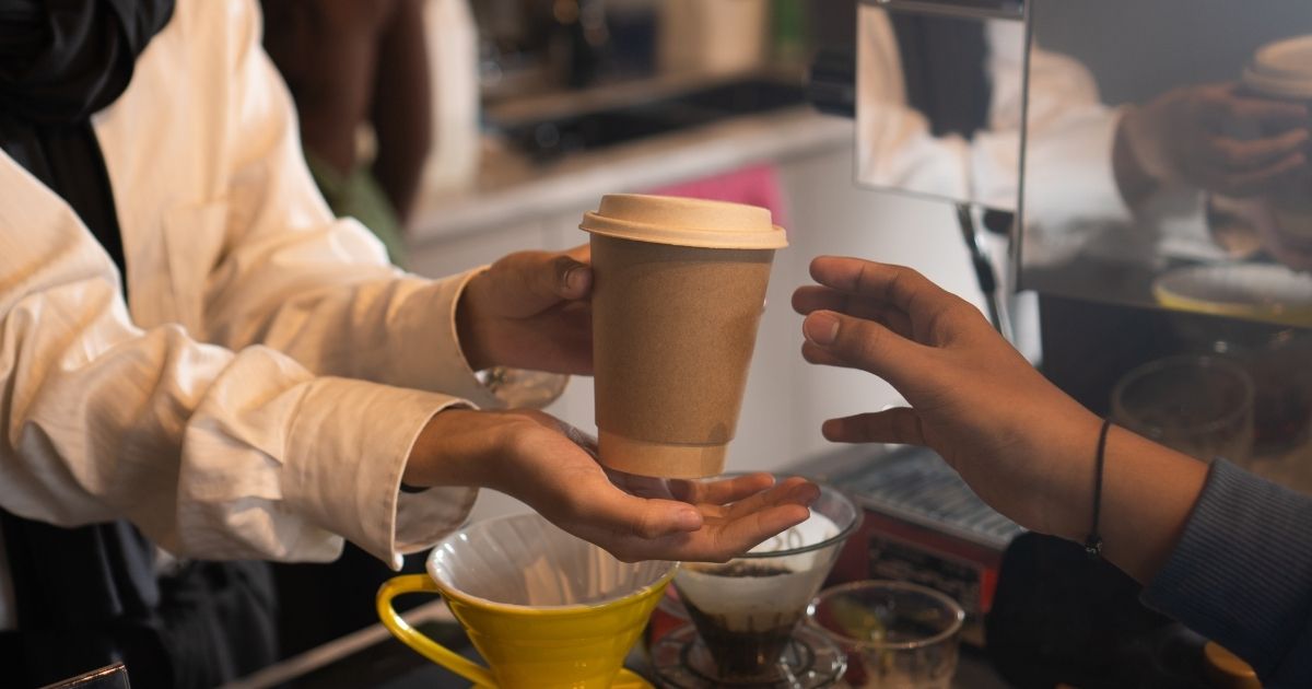 An assortment of different coffee drinks including lattes, cold brew, matcha, and iced tea on a café table
