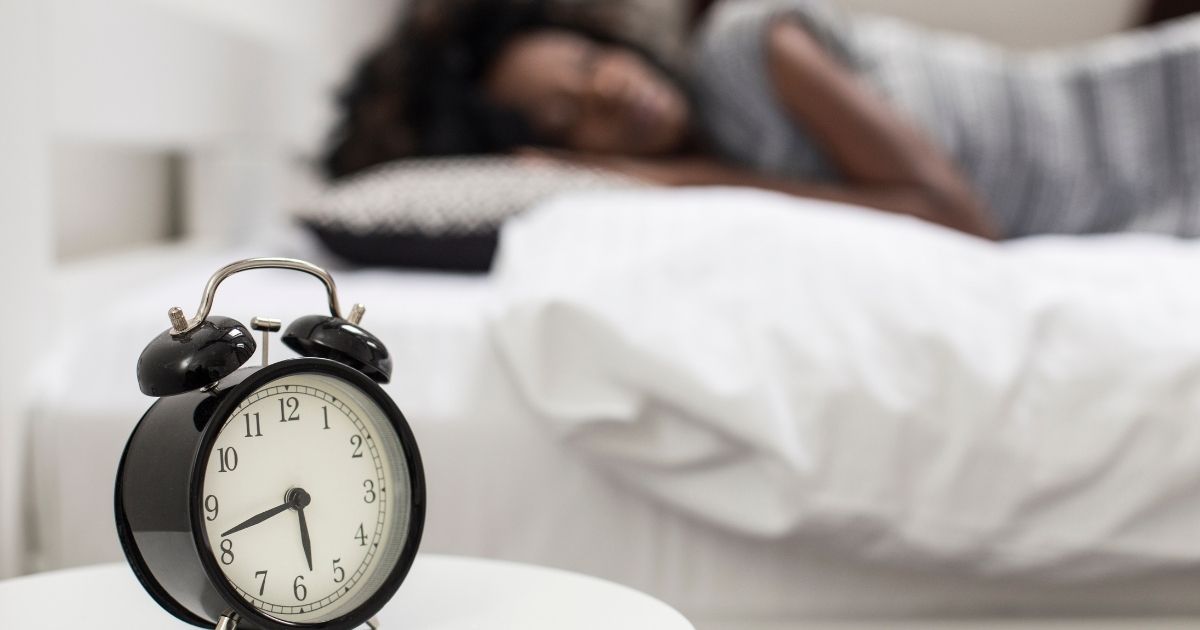 A clock next to a coffee cup showing the concept of a caffeine cutoff time for better sleep